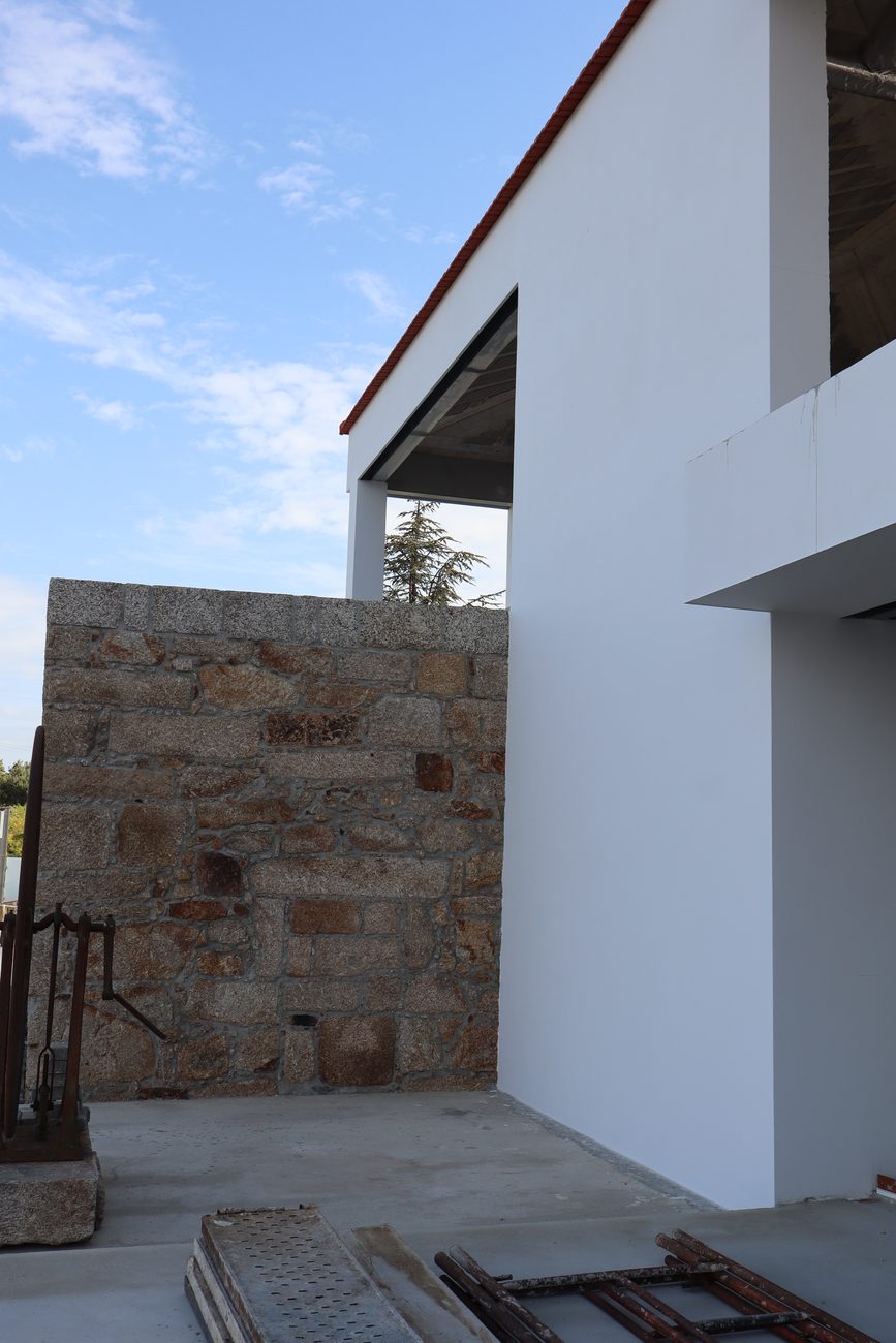 Fachada branca junto ao muro de granito — Edifício de restauração Leitão do Petti, Penafiel