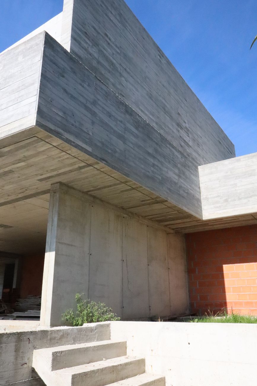 Volume em betão aparente sobre escadas exteriores — Casa Santa Luzia, Penafiel