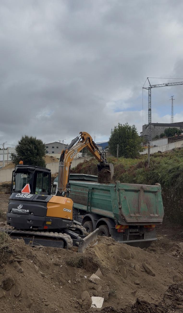 Escavadora e camião em terreno em desnível — terraplanagem e movimentação de terras